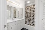 Updated full bathroom with a double vanity, tub, and shower, perfect for shared routines and easy cleanup after the beach.