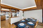 Gather around the dining table beside the open kitchen, designed for group meals and Cape Cod vacation living.