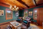 Cozy library with deep green walls, leather chairs, and custom details creates a stylish retreat for reading or quiet evenings.