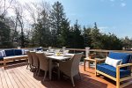 Expansive deck with outdoor dining and lounge seating makes it easy to enjoy sunny afternoons and relaxed Cape Cod meals outside.