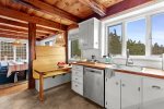 Kitchen banquette and sink area add charm and function, with beautiful natural light and warm wood accents throughout.