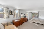 Spacious queen bedroom with dresser and sliding door access to the outdoors, a calm retreat after Cape Cod Bay swims and sunset walks.