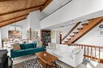 Open concept living area with comfortable seating, lofted ceiling, and easy flow to the dining space in this Wellfleet vacation rental.