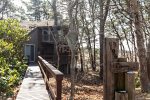 Private approach to Marshside Escape, a wooded South Wellfleet vacation rental tucked above the marsh with elevated privacy.