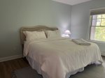 Main floor bedroom with king size bed, TV & attached laundry room