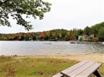 Sandy beach with picnic tables, swings, and charcoal grills
