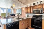 updated kitchen cabinets, granite counter tops, microwave, range-oven, dishwasher, coastal wall art