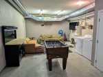 Hang out area in the garage with a TV, couches, ski tuning area, and foosball