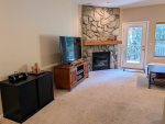 Living room fireplace, flat screen TV, and bluetooth speaker. 