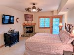 Master bedroom with ensuite bathroom, Flat screen TV, private gas fireplace, and reading chair