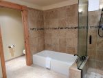 Bathtub and private toilet area with sliding door in the Master bathroom