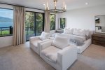 Main floor primary bedroom suite with waterfront views and luxury linens.