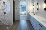 Primary bathroom with double sided steam shower, double vanity and private toilet. 