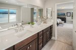 Primary bathroom with double vanity, jetted tub, and custom tiled shower