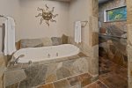 Stone floors with jetted tub and walk in shower.