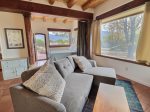 Main queen bed in sleeping area with privacy curtain to separate from the living spaces shades up
