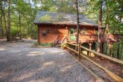 PREMIER CABIN!!!  Fox Ridge- Perfect cabin nestled in the woods with a large hot tub, TV hanging on wall, and a large stacked rock firepit with split rail fence around seating area. 