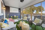 Screen-porch living space with cozy seating and projector TV