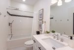 Large, full bathroom with custom-tiled tub and shower