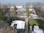 Drone shot from above the house white roof, beach path to the right also