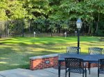 The outdoor area features a table for dining and a putting green, offering a great space for outdoor meals and a fun way to practice your golf skills.