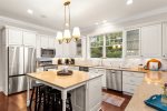 A Chefs Delight  This modern kitchen features a spacious island and sleek stainless steel appliances.