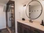 The lower level bathroom offers a custom tile shower and plenty of storage space.