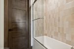 The ensuite for the guest bedroom offers a custom tile shower & tub. 