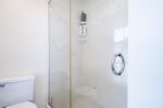 An expansive glass shower and toilet are located in the Master Bathroom with a privacy pocket door.