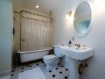 The spacious upstairs bathroom features a traditional ball and claw tub w/shower, pedestal sink and storage.  This bathroom is shared between the two bedrooms.